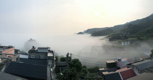 High angle view of buildings by sea against sky