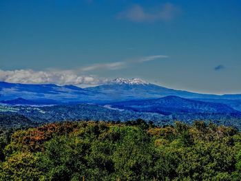 Scenic view of mountains against blue sky