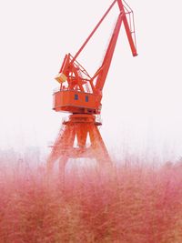 Low angle view of crane at construction site against sky