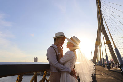 People standing on bridge against sky