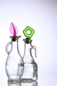 Close-up of empty glass bottles against white background