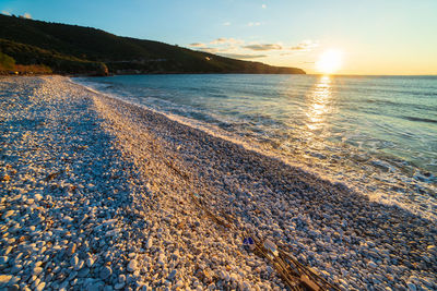 Scenic view of beach against sky during sunset
