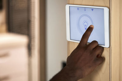 Man operating lighting system on tablet pc at home