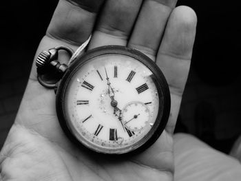 Cropped hand holding pocket watch