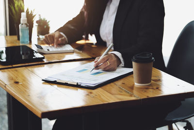 Midsection of woman working on table