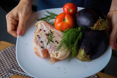 Cropped image of hands holding food plate