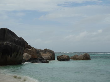Rocks by sea against sky
