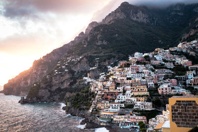 Aerial view of townscape by sea against sky