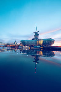 Illuminated pier over sea against blue sky