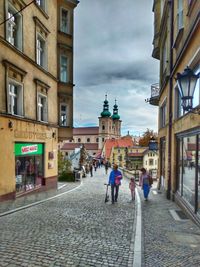 People walking on street amidst buildings in city