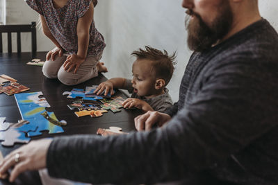 Family completing puzzle at home during isolation