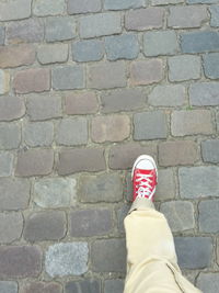 Low section of man standing on cobblestone