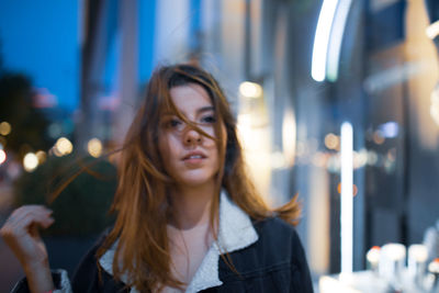 Young woman at illuminated city