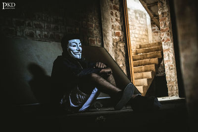 Statue of man sitting on wall