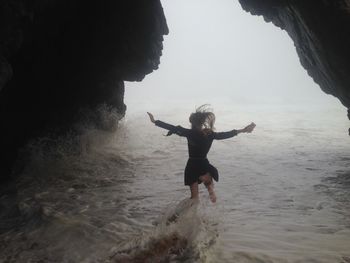 Man jumping in sea against sky