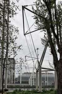 Low angle view of electricity pylon in city