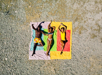 From above drone view of multiracial man and woman lounging on inflatable floats in clean lake water during summer vacation