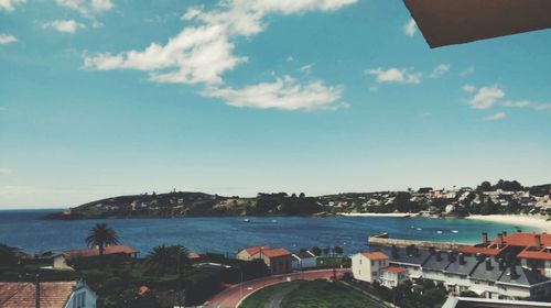 Panoramic view of city by sea against sky