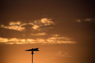 Low angle view of silhouette weathercock against sky during sunset