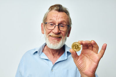 Portrait of man holding fruit against white background