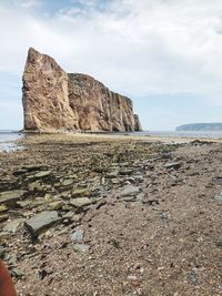 Rock formations on beach against sky