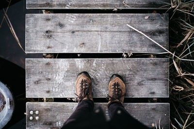 Low section of person standing on wooden floor