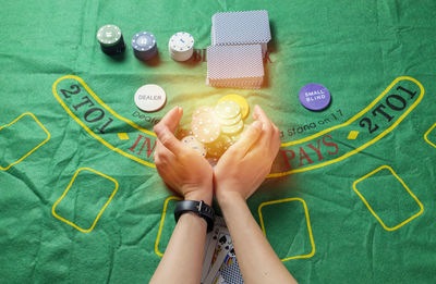 High angle view of woman holding paper painting on table