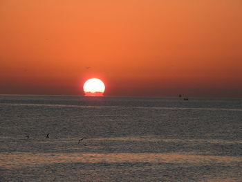 Scenic view of sea against orange sky