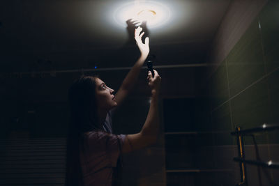 Rear view of woman holding illuminated light