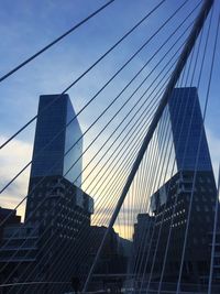 Low angle view of suspension bridge against sky
