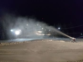 People on beach against sky at night