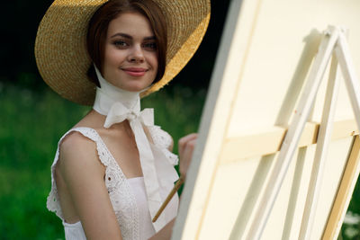 Portrait of smiling young woman wearing hat