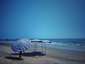 Scenic view of beach against clear blue sky