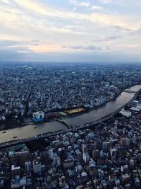 Aerial view of city against cloudy sky