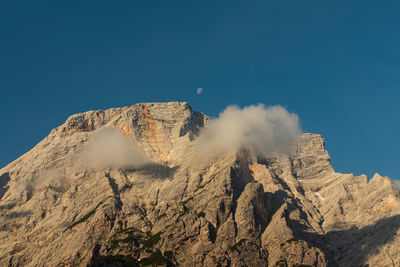 Panoramic view of rocky mountains against clear blue sky