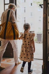 Senior woman with granddaughter leaving from building