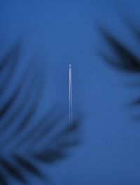 Close-up of airplane flying against blue sky