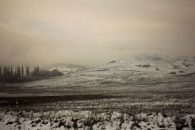 Scenic view of snow covered field against sky