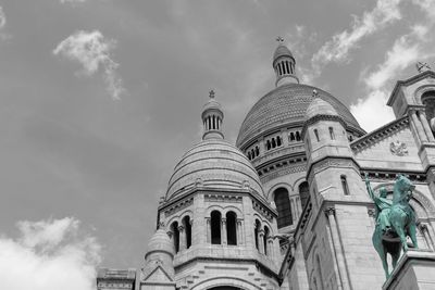 Low angle view of statues on building against sky