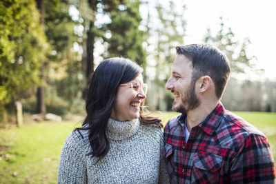 Attractive young couple sharing a laugh outdoors.