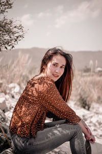 Portrait of young woman sitting outdoors