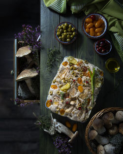 Italian focaccia with mushrooms and vegetables, green olives on a woode table