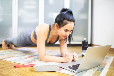 Young woman using mobile phone at home