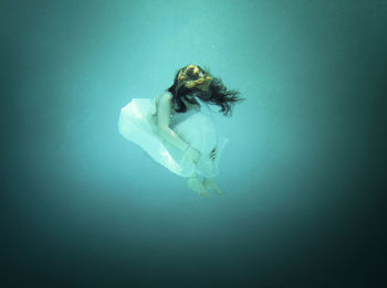 High angle view of beautiful woman wearing dress floating undersea