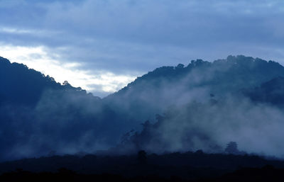 Scenic view of mountains against cloudy sky