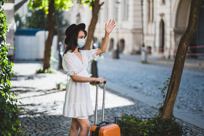 Woman wearing mask standing on road