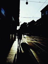 Silhouette man in city against sky