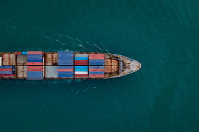 Containers ship corgo logistic transportation floating at sea aerial top view