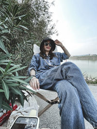 Young woman sitting by plants