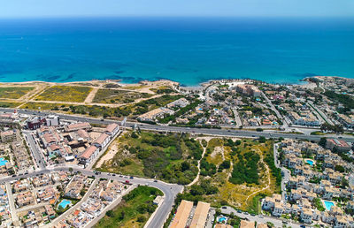 High angle view of townscape by sea against sky